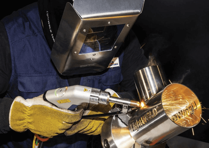 ชายกำลัง เชื่อมเลเซอร์ ด้วยเทคโนโลยีทันสมัยในขณะที่ทำงานกับวัสดุโลหะที่มีความทนทาน โดยใช้เครื่องเชื่อมเลเซอร์ที่มีความแม่นยำสูงเพื่อการเชื่อมที่สะอาดและแข็งแรง