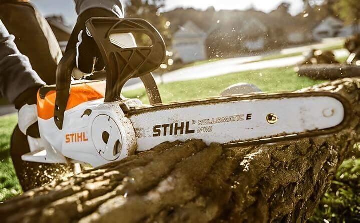 ชายกำลังกตัดไม้ท่อนด้วยรุ่นไร้สายกลางแจ้ง แสดงถึงความสะดวกและง่ายดายในการใช้งานโดยไม่ต้องใช้สายไฟ