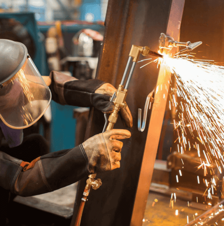 ชายกำลังใช้ชุดตัดแก๊สที่สถานที่ทำงานเพื่อการตัดโลหะอย่างแม่นยำ